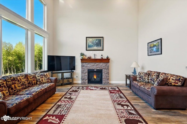 2034 E Sage Rd, Wasilla, AK 99654 - living room featuring wood finished floors, a high ceiling, and a fireplace