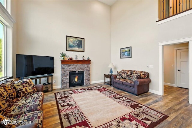 2034 E Sage Rd, Wasilla, AK 99654 - living area featuring a high ceiling, wood finished floors, baseboards, and a stone fireplace