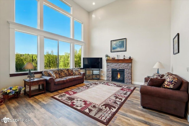 2034 E Sage Rd, Wasilla, AK 99654 - living room with a towering ceiling, wood finished floors, a fireplace, recessed lighting, and baseboards