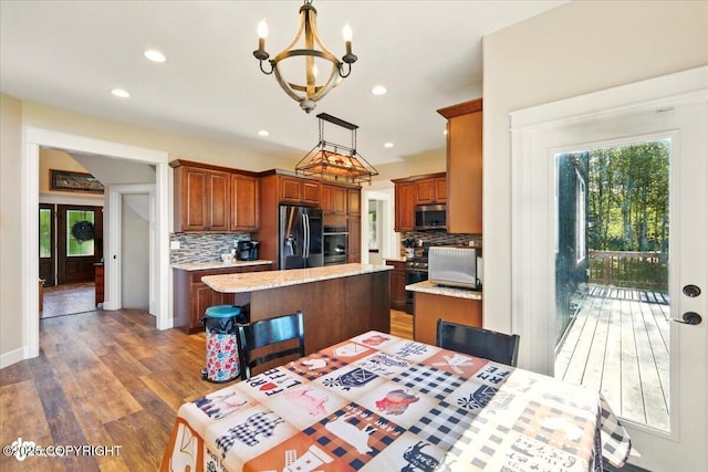 2034 E Sage Rd, Wasilla, AK 99654 - kitchen featuring stainless steel microwave, fridge with ice dispenser, wall oven, a kitchen island, and decorative backsplash
