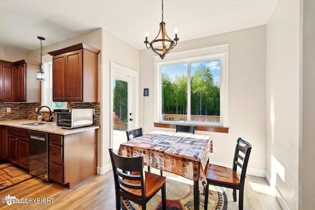 2034 E Sage Rd, Wasilla, AK 99654 - dining area featuring light wood-style floors, a chandelier, and baseboards