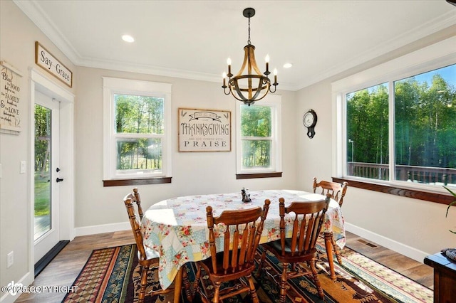 2034 E Sage Rd, Wasilla, AK 99654 - dining area featuring healthy amount of natural light, a chandelier, baseboards, ornamental molding, and wood finished floors