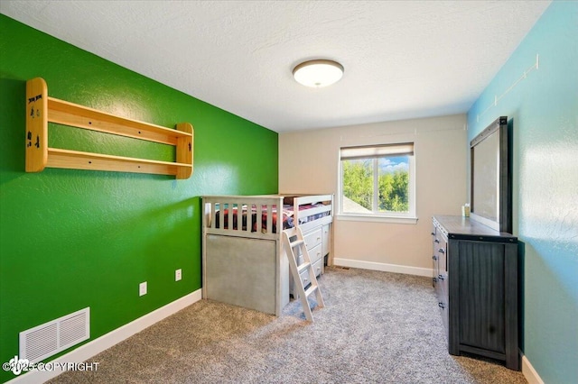 2034 E Sage Rd, Wasilla, AK 99654 - carpeted bedroom featuring a textured wall, baseboards, and a textured ceiling