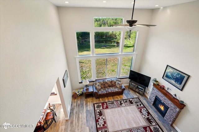 2034 E Sage Rd, Wasilla, AK 99654 - living area featuring plenty of natural light, a fireplace, ceiling fan, wood finished floors, and a high ceiling
