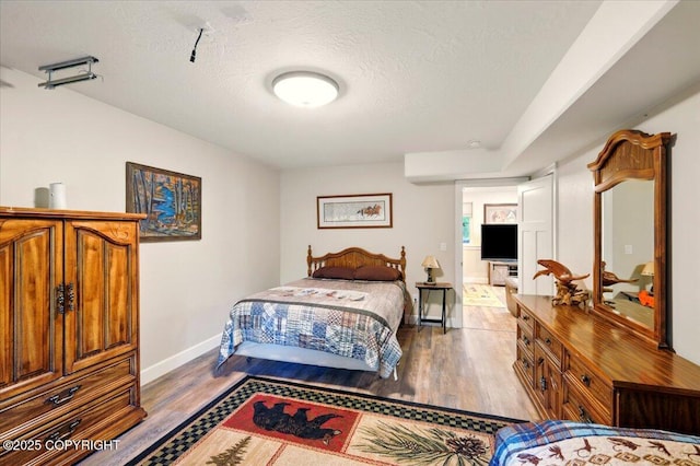 2034 E Sage Rd, Wasilla, AK 99654 - bedroom featuring wood finished floors, a textured ceiling, and baseboards