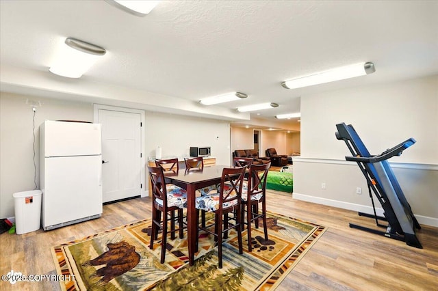2034 E Sage Rd, Wasilla, AK 99654 - dining space with light wood-type flooring, baseboards, and a textured ceiling