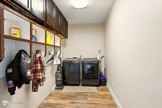 2034 E Sage Rd, Wasilla, AK 99654 - laundry area with cabinet space, washer and clothes dryer, light wood-type flooring, and baseboards