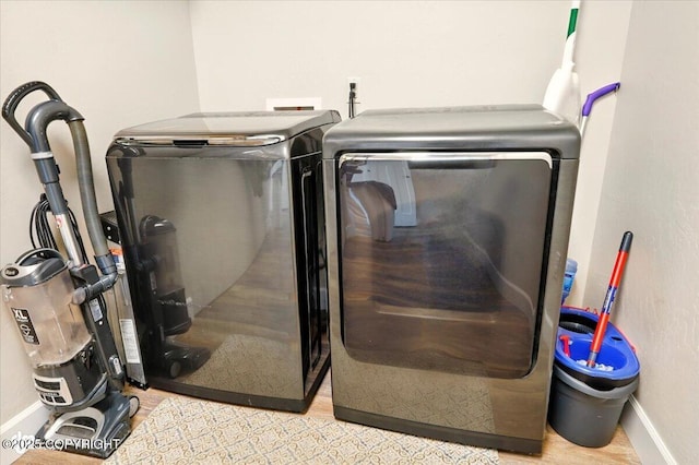 2034 E Sage Rd, Wasilla, AK 99654 - laundry view of baseboards, washer and clothes dryer, and wood finished floors