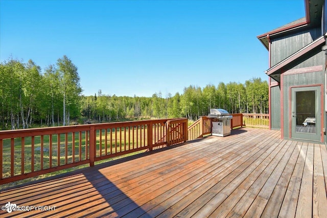 2034 E Sage Rd, Wasilla, AK 99654 - wooden deck featuring a grill, a view of trees, and a lawn