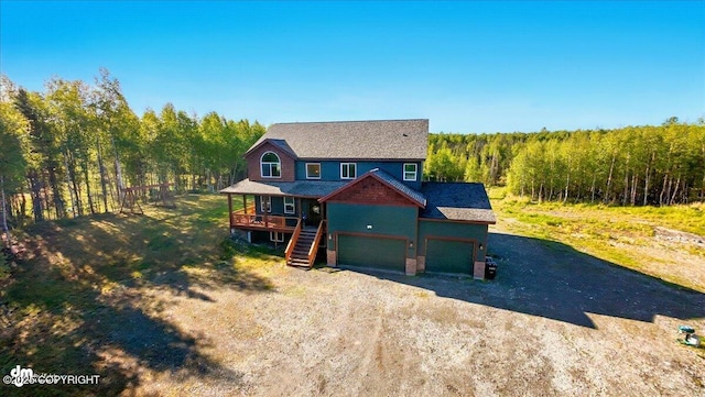 2034 E Sage Rd, Wasilla, AK 99654 - view of front of house featuring driveway, a wooded view, and a deck