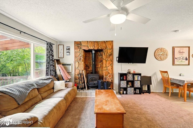 751 W Crestwood Ave, Wasilla, AK 99654 - carpeted living area featuring a wood stove, a textured ceiling, ceiling fan, and an AC wall unit