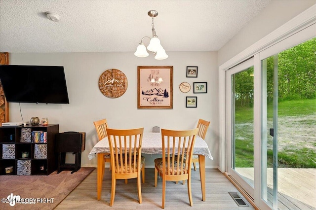 751 W Crestwood Ave, Wasilla, AK 99654 - dining room with a chandelier, healthy amount of natural light, a textured ceiling, and wood finished floors