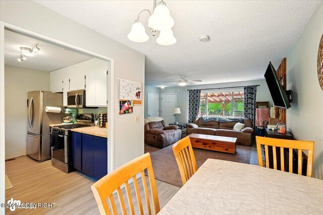 751 W Crestwood Ave, Wasilla, AK 99654 - kitchen featuring stainless steel appliances, white cabinets, a chandelier, light wood-style floors, and light countertops