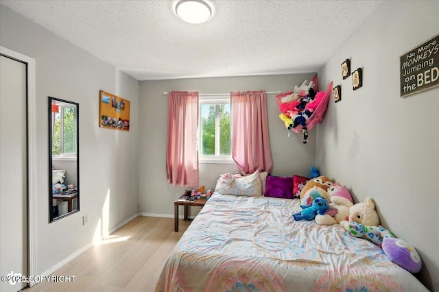 751 W Crestwood Ave, Wasilla, AK 99654 - bedroom with wood finished floors, a textured ceiling, and baseboards