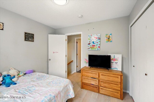 751 W Crestwood Ave, Wasilla, AK 99654 - bedroom with light wood-style floors, a closet, baseboards, and a textured ceiling
