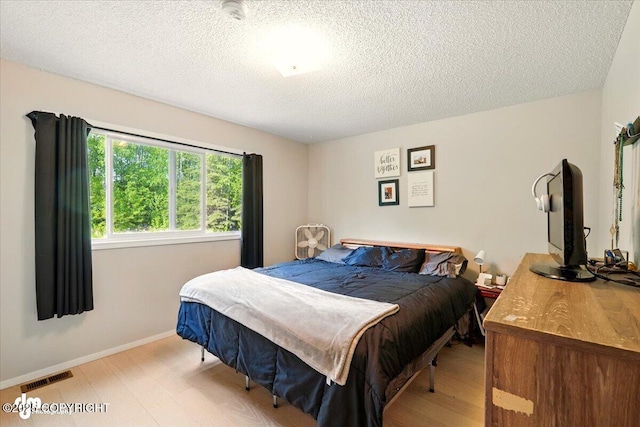 751 W Crestwood Ave, Wasilla, AK 99654 - bedroom with light wood-type flooring, a textured ceiling, and baseboards