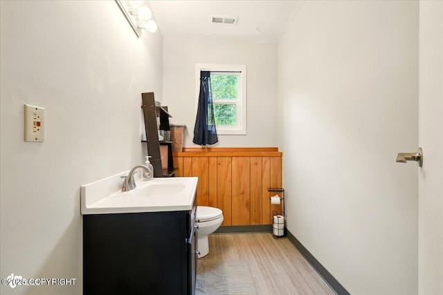 751 W Crestwood Ave, Wasilla, AK 99654 - bathroom with toilet, vanity, a wainscoted wall, wood finished floors, and wooden walls