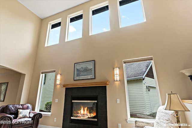 2931 Captain Cook Estates Cir, Anchorage, AK 99517 - living room featuring a tiled fireplace, a towering ceiling, and arched walkways