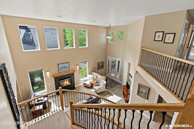 2931 Captain Cook Estates Cir, Anchorage, AK 99517 - carpeted living area featuring healthy amount of natural light, a high ceiling, a tile fireplace, baseboards, and stairway