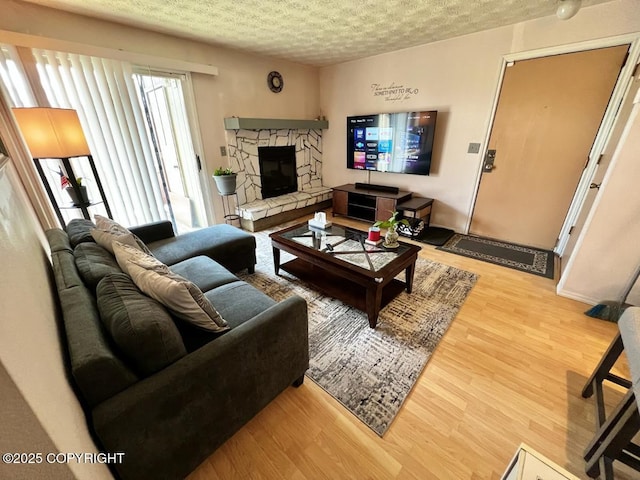 10250 Jamestown Dr # B-09, Anchorage, AK 99507 - living area with light wood-type flooring, a fireplace, and a textured ceiling