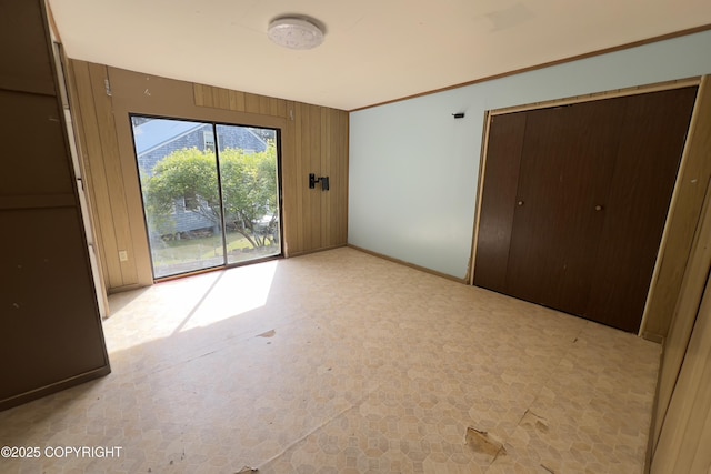 450 Noview Ave, Homer, AK 99603 - unfurnished bedroom with access to outside, baseboards, wooden walls, and a closet