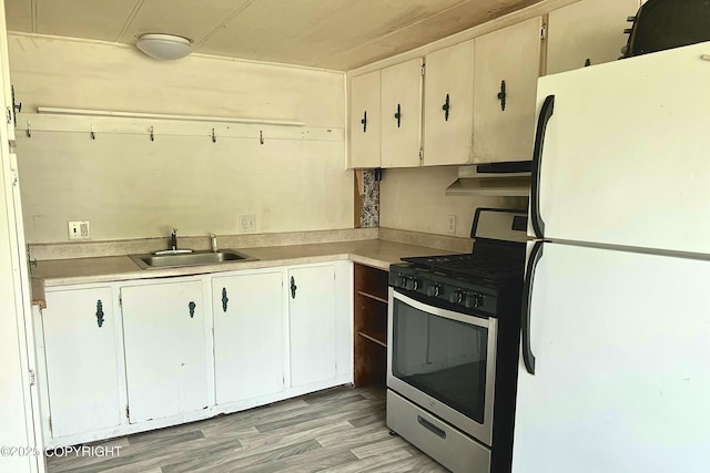 450 Noview Ave, Homer, AK 99603 - kitchen with freestanding refrigerator, stainless steel gas range oven, a sink, and light countertops