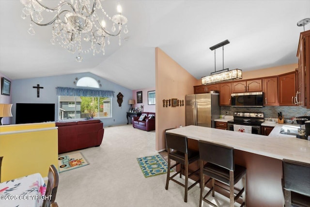 4245 Scenic View Dr, Anchorage, AK 99504 - kitchen with stainless steel appliances, lofted ceiling, a chandelier, light colored carpet, and a peninsula