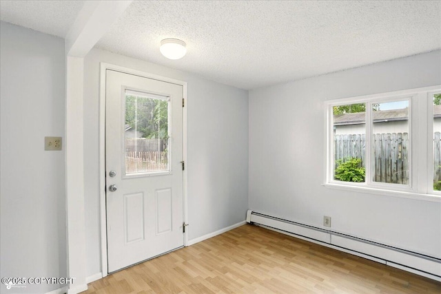 2527 Cottonwood St, Anchorage, AK 99508 - entryway featuring baseboard heating, light wood-type flooring, healthy amount of natural light, and a textured ceiling