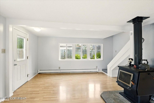 2527 Cottonwood St, Anchorage, AK 99508 - living room with a wood stove, light wood finished floors, baseboard heating, baseboards, and stairway