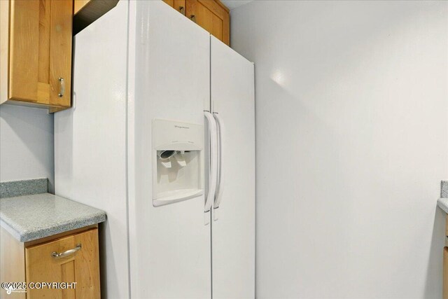 2527 Cottonwood St, Anchorage, AK 99508 - kitchen with white fridge with ice dispenser, light countertops, and brown cabinetry
