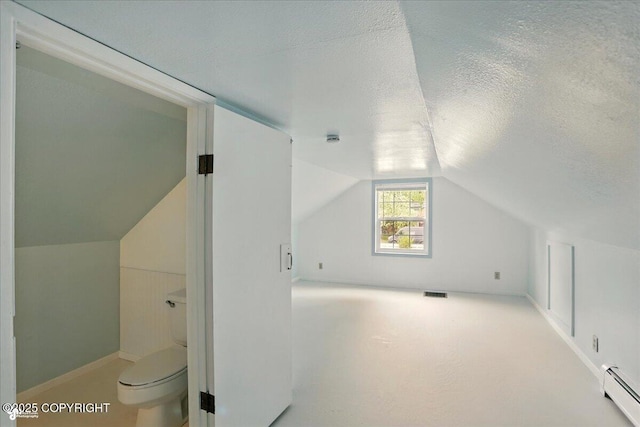 2527 Cottonwood St, Anchorage, AK 99508 - additional living space with a baseboard heating unit, a textured ceiling, and lofted ceiling