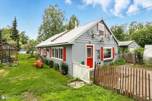 2527 Cottonwood St, Anchorage, AK 99508 - view of front of house with a greenhouse, an outdoor structure, and metal roof