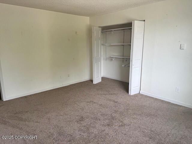 1008 Wildrose Ct, Anchorage, AK 99518 - unfurnished bedroom featuring carpet, a closet, a textured ceiling, and baseboards
