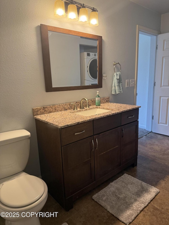 1008 Wildrose Ct, Anchorage, AK 99518 - bathroom with stacked washing machine and dryer, vanity, and toilet
