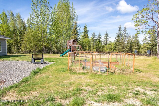 37653 Deville Rd, Soldotna, AK 99669 - view of green lawn featuring a playground and a vegetable garden