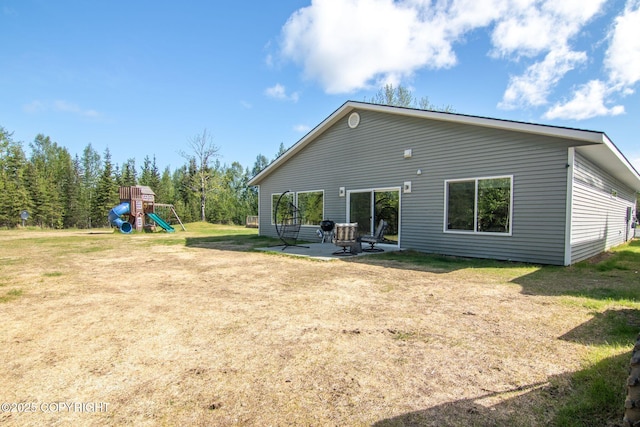 37653 Deville Rd, Soldotna, AK 99669 - back of property featuring a playground, a lawn, and a patio area