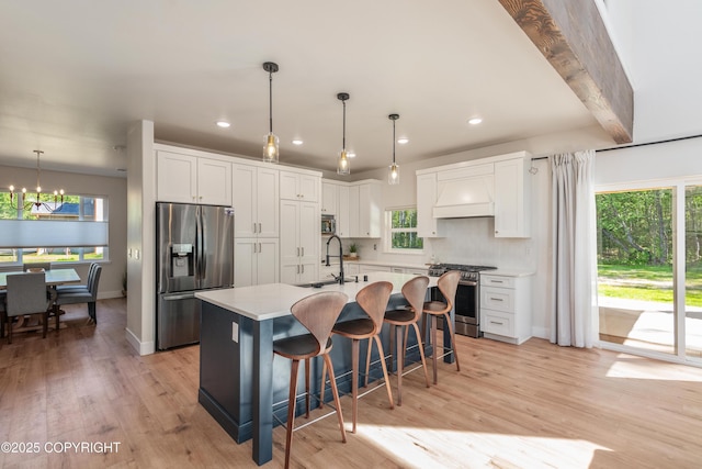 1645 N Vroman Dr, Palmer, AK 99645 - kitchen with stainless steel appliances, a chandelier, white cabinetry, a center island with sink, and light countertops