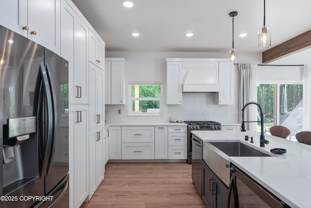 1645 N Vroman Dr, Palmer, AK 99645 - kitchen with stainless steel appliances, custom range hood, white cabinetry, decorative backsplash, and light stone counters
