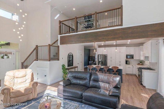 1645 N Vroman Dr, Palmer, AK 99645 - living room with a towering ceiling, light wood finished floors, stairway, baseboards, and recessed lighting