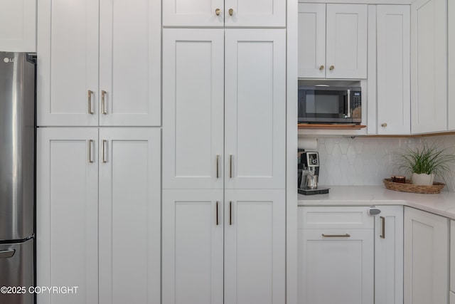 1645 N Vroman Dr, Palmer, AK 99645 - kitchen with freestanding refrigerator, white cabinetry, and backsplash