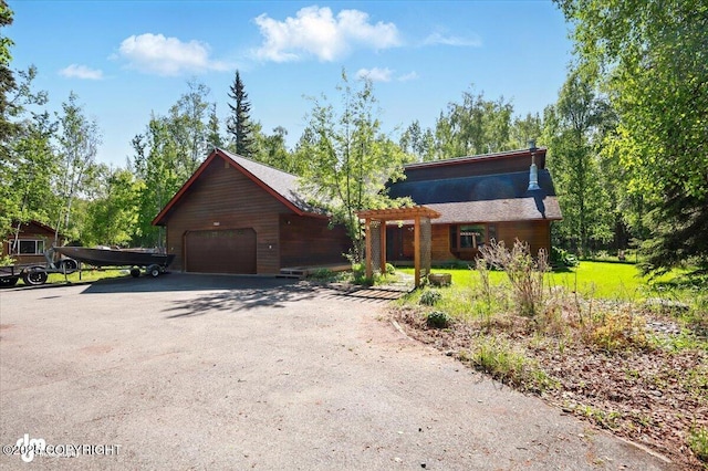 7965 S Settlers Bay Dr, Wasilla, AK 99623 - view of front of home featuring asphalt driveway, a pergola, and a detached garage