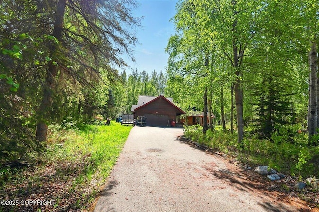 7965 S Settlers Bay Dr, Wasilla, AK 99623 - view of front of house with dirt driveway and a view of trees