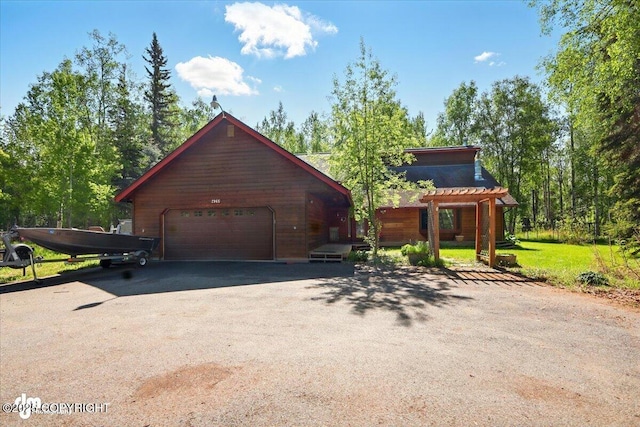 7965 S Settlers Bay Dr, Wasilla, AK 99623 - view of front facade with asphalt driveway, a garage, a pergola, and a front yard