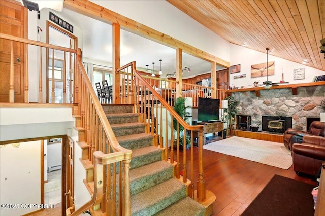 7965 S Settlers Bay Dr, Wasilla, AK 99623 - stairway featuring wood finished floors, wood ceiling, a stone fireplace, a ceiling fan, and high vaulted ceiling