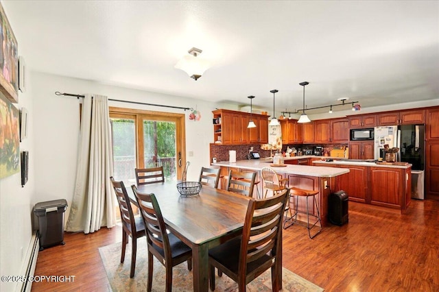 7965 S Settlers Bay Dr, Wasilla, AK 99623 - dining area featuring dark wood-style floors, a baseboard heating unit, and rail lighting
