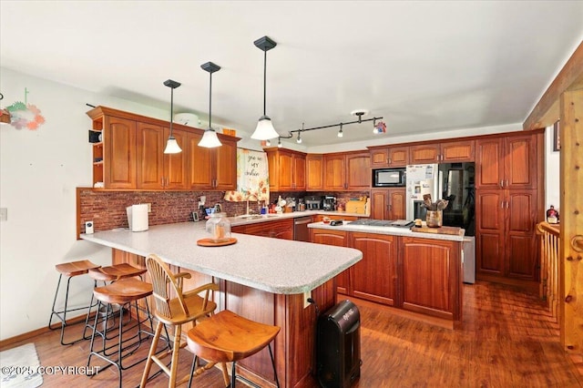 7965 S Settlers Bay Dr, Wasilla, AK 99623 - kitchen with black microwave, a peninsula, light countertops, a sink, and tasteful backsplash