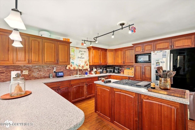 7965 S Settlers Bay Dr, Wasilla, AK 99623 - kitchen with a sink, black microwave, freestanding refrigerator, light countertops, and brown cabinets