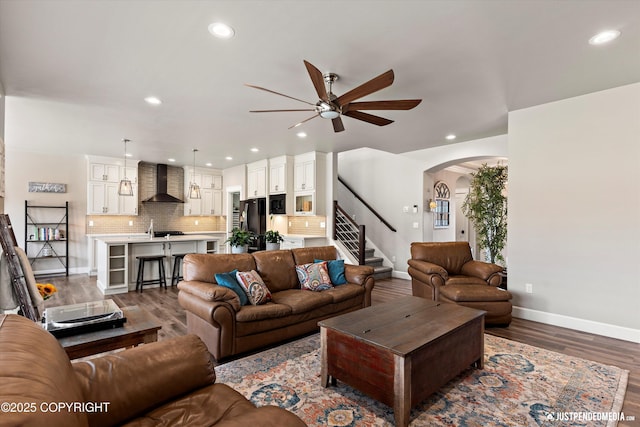 5167 E Henhouse Loop, Wasilla, AK 99654 - living area featuring baseboards, a ceiling fan, arched walkways, stairway, and wood finished floors