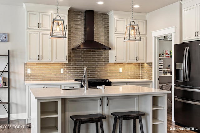 5167 E Henhouse Loop, Wasilla, AK 99654 - kitchen with refrigerator with ice dispenser, wall chimney exhaust hood, open shelves, light countertops, and recessed lighting