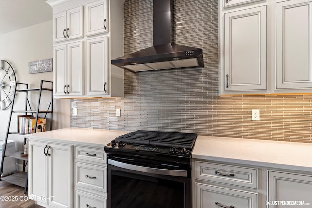 5167 E Henhouse Loop, Wasilla, AK 99654 - kitchen with wall chimney exhaust hood, gas stove, decorative backsplash, white cabinetry, and light stone countertops